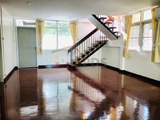 Spacious living room with staircase and large windows