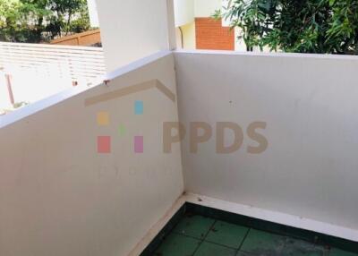 Small balcony with green floor tiles and white walls