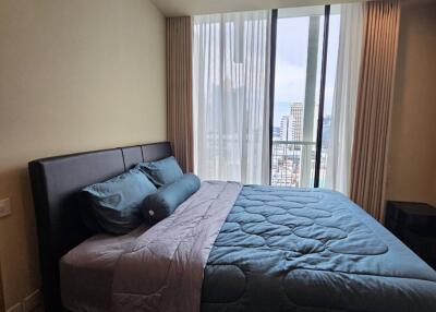 A modern bedroom with a large bed and a window view