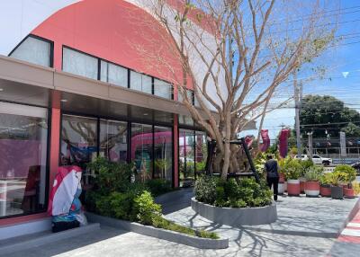 Exterior of a modern building with large windows and a landscaped entrance