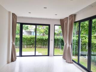 Spacious living room with large windows and garden view