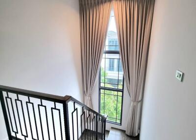 Modern staircase with wooden steps and a large window