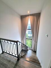 Modern staircase with wooden steps and a large window