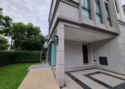 exterior view of a modern townhouse with lush green surroundings