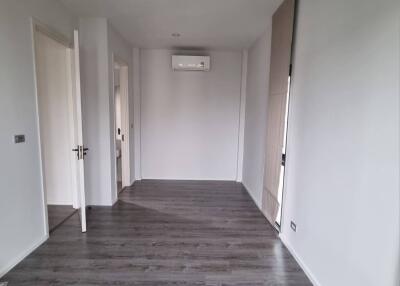 Empty bedroom with wooden flooring and natural light