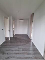 Empty bedroom with wooden flooring and natural light