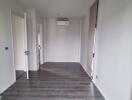 Empty bedroom with wooden flooring and natural light