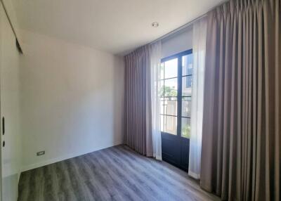 Empty bedroom with large window and curtains