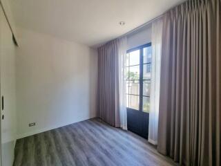 Empty bedroom with large window and curtains