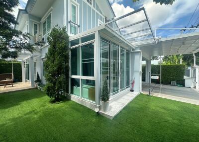 Modern house exterior with a lawn and glass windows