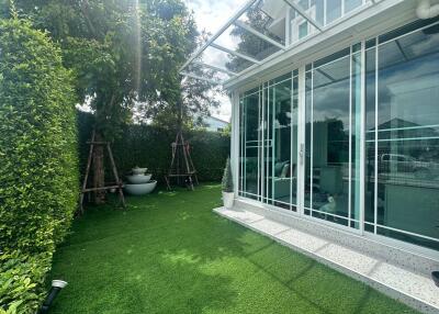 Modern glass-walled room with adjacent garden area