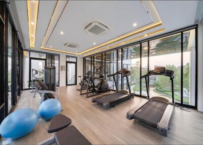 Modern gym with various exercise equipment and large windows