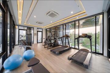 Modern gym with various exercise equipment and large windows