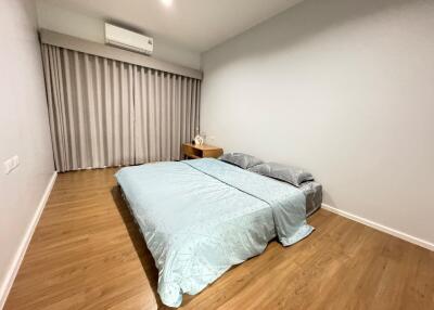 Spacious bedroom with large bed and wooden flooring