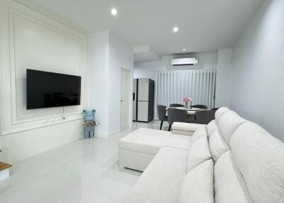 Modern living room with white sofa and wall-mounted TV