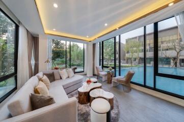 Spacious living room with large windows and a pool view