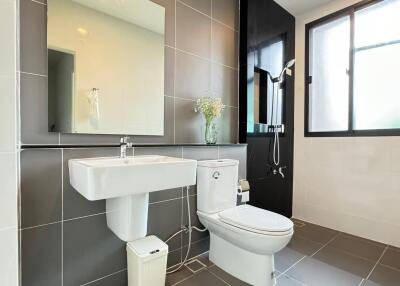 Modern bathroom with tiled walls, sink, and shower