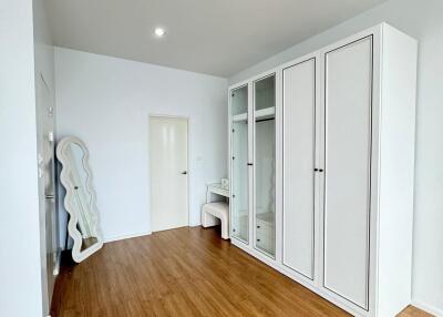 Spacious bedroom with hardwood flooring and ample storage