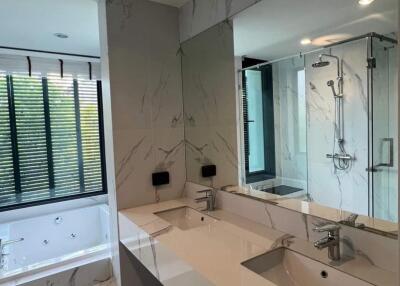 Modern bathroom with double sink, walk-in shower, and bathtub