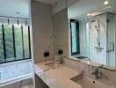 Modern bathroom with double sink, walk-in shower, and bathtub