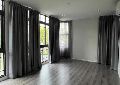 Spacious living room with large windows and dark curtains