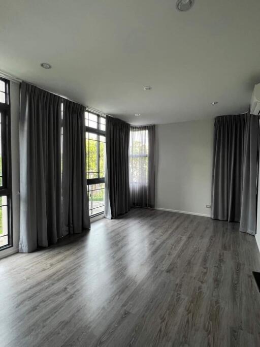 Spacious living room with large windows and dark curtains