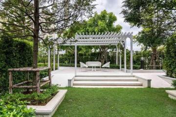 Well-maintained backyard with pergola and seating area