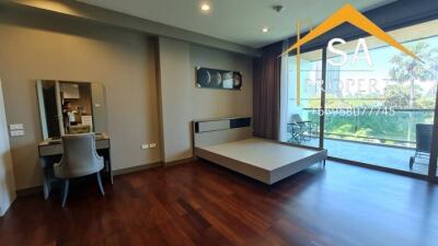 Spacious bedroom with balcony and wooden flooring