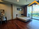 Spacious bedroom with balcony and wooden flooring