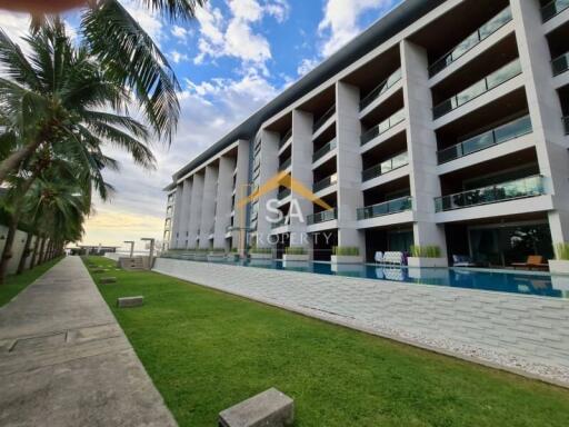 Modern apartment building with outdoor pool and green lawn