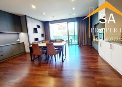 Modern living and dining area with wooden flooring and large windows