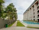 View of the apartment building with a swimming pool and garden area