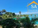 Scenic view of a tropical outdoor area with a swimming pool and ocean backdrop