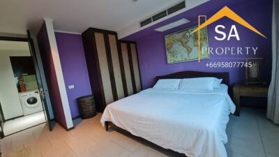 Spacious bedroom with purple walls and queen-sized bed