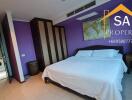 Spacious bedroom with purple walls and queen-sized bed