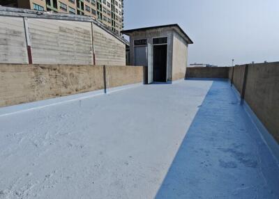 Building rooftop with blue flooring and small structure