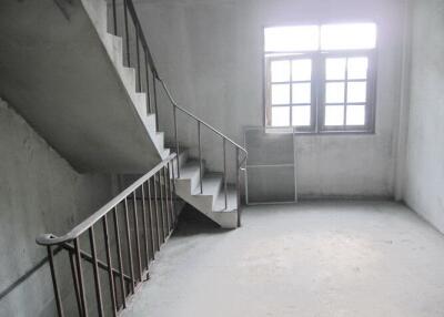 Unfinished room with a staircase and window