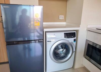 Modern kitchen with a washing machine and refrigerator