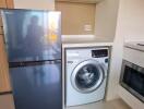 Modern kitchen with a washing machine and refrigerator