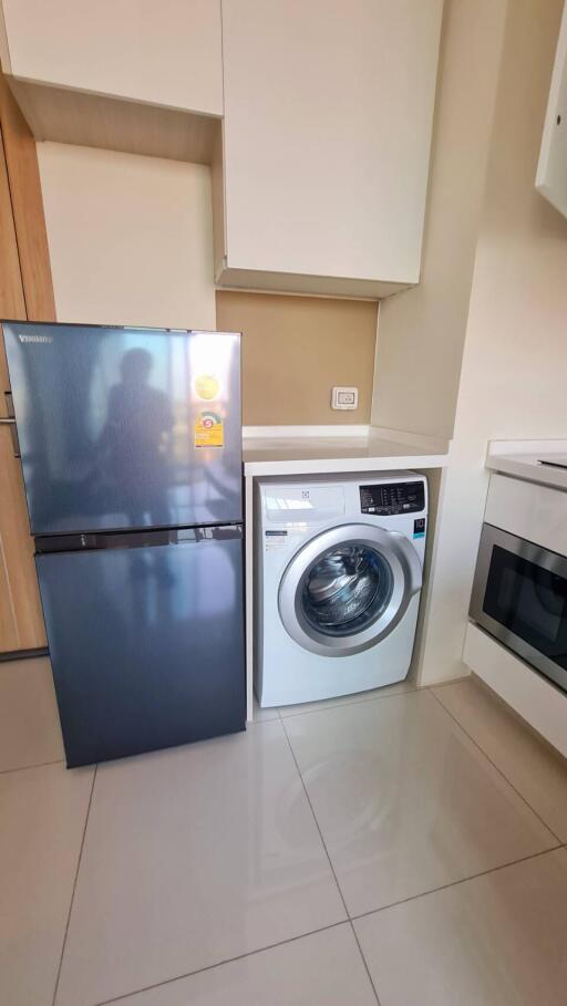 Modern kitchen with a washing machine and refrigerator