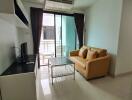 Modern living room with sofa and TV, opening to a balcony