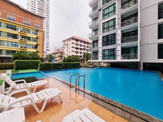 Outdoor swimming pool area with buildings in the background