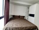 Cozy bedroom with brown bedding and white wardrobe