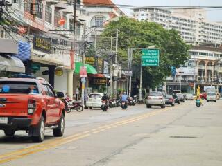 Busy city street with vehicles and shops