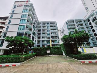 Exterior view of a multi-story residential building with greenery