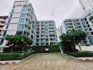 Exterior view of a multi-story residential building with greenery