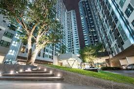 Outside view of a modern apartment complex with green areas and a tree