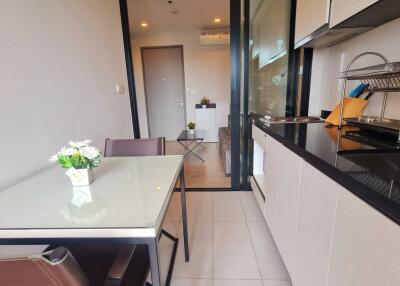 Modern kitchen and dining area with glass table and flowers