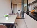 Modern kitchen and dining area with glass table and flowers