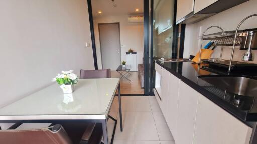 Modern kitchen and dining area with glass table and flowers